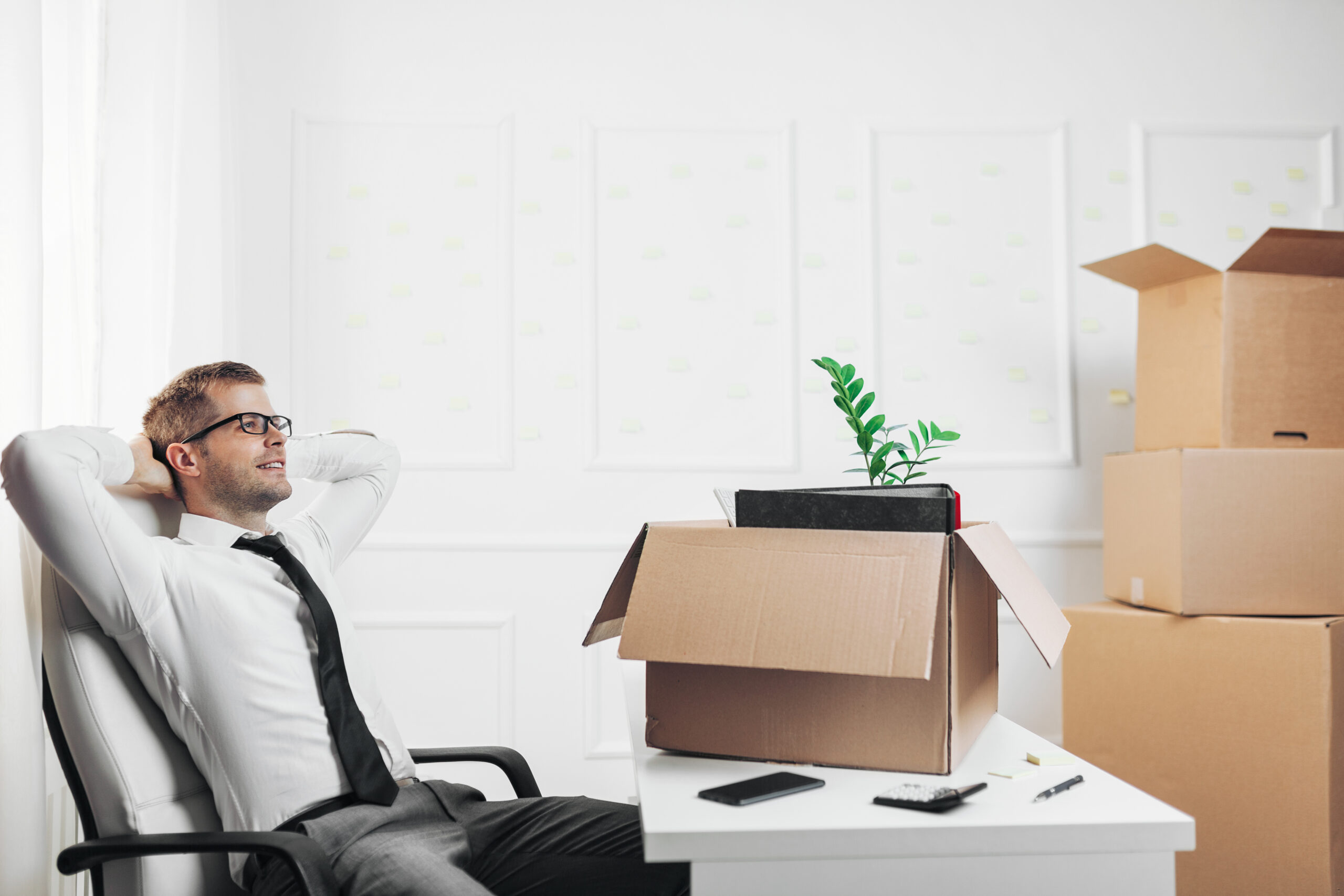 A man from Expert Removals sitting at a desk with boxes in front of him.