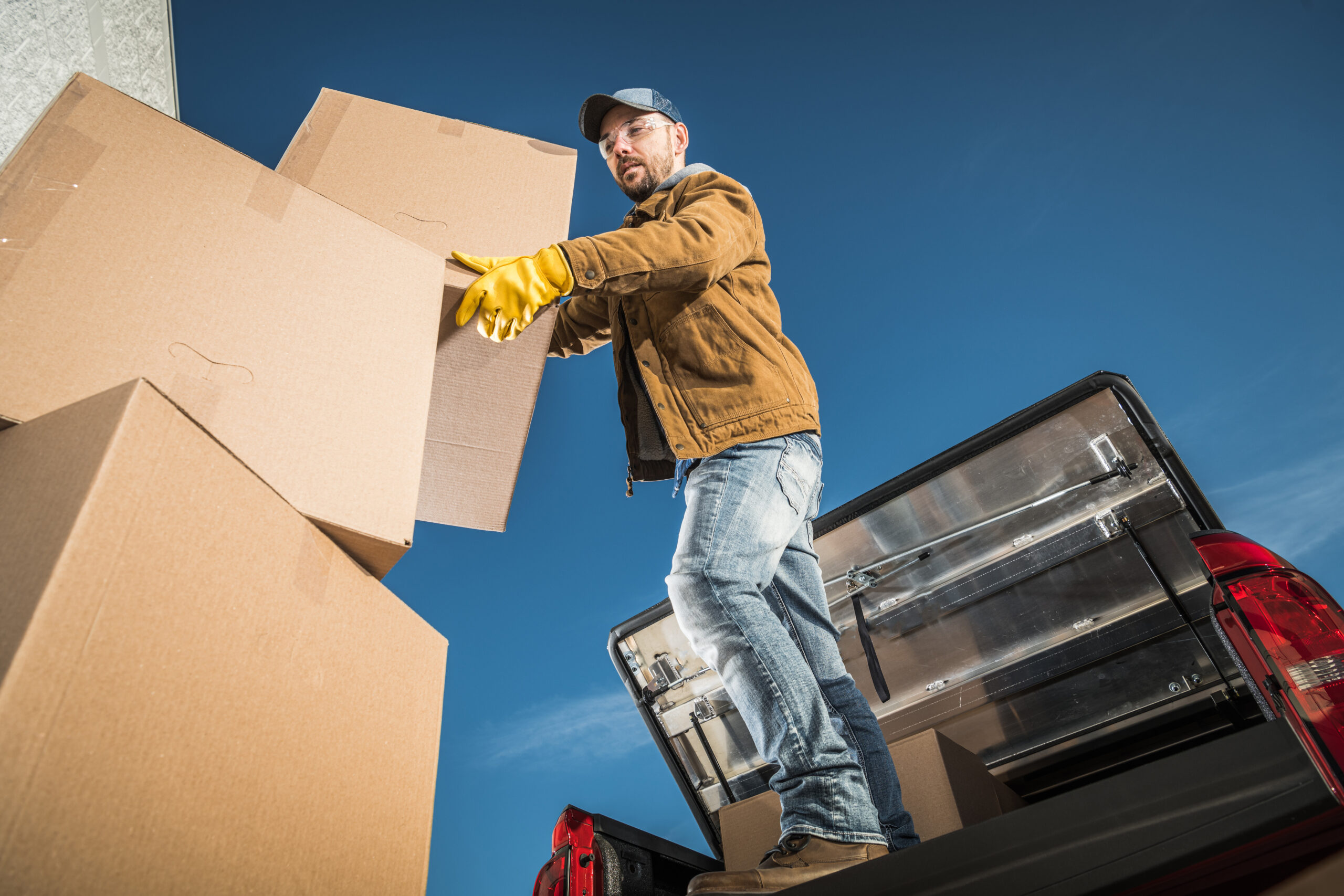 A man skilled in expert removals loading boxes into the back of a truck.