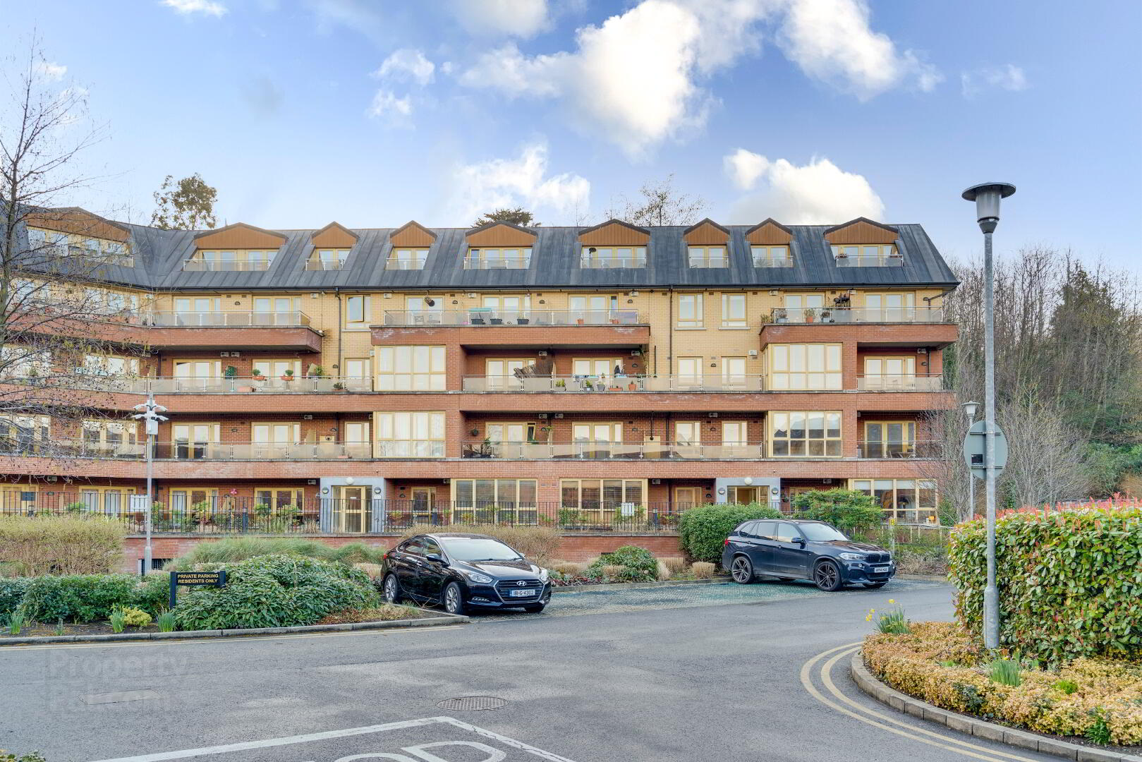 An apartment building with cars parked in front of it, expertly equipped for removals.