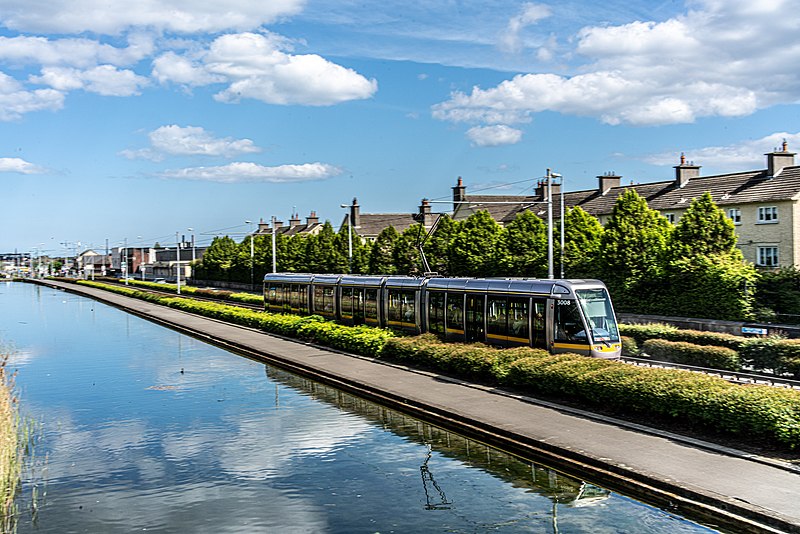 A train on a track next to a waterway, expertly maneuvering along its course.