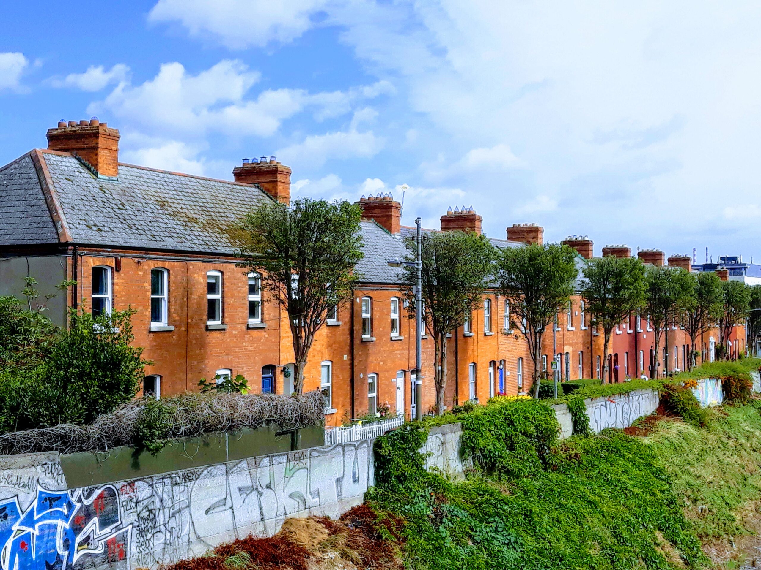 A row of red brick houses next to a river, with expert removals services available.