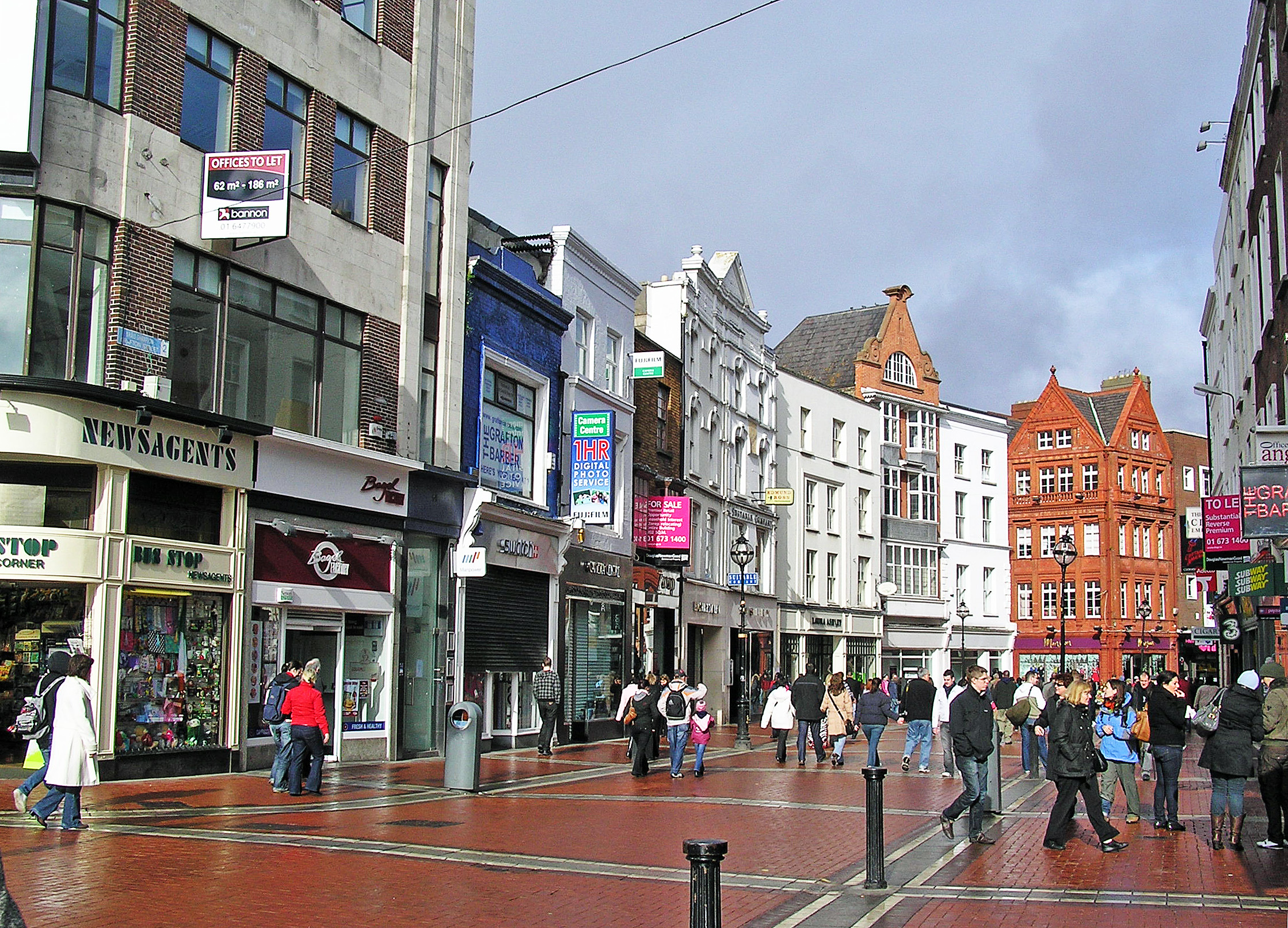 A crowd of people walking down a city street during the Expert Removals event.