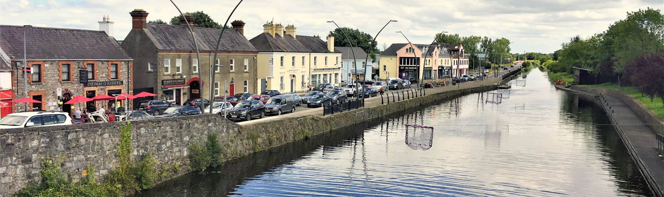 A canal with cars parked next to it, offering expert removals services.