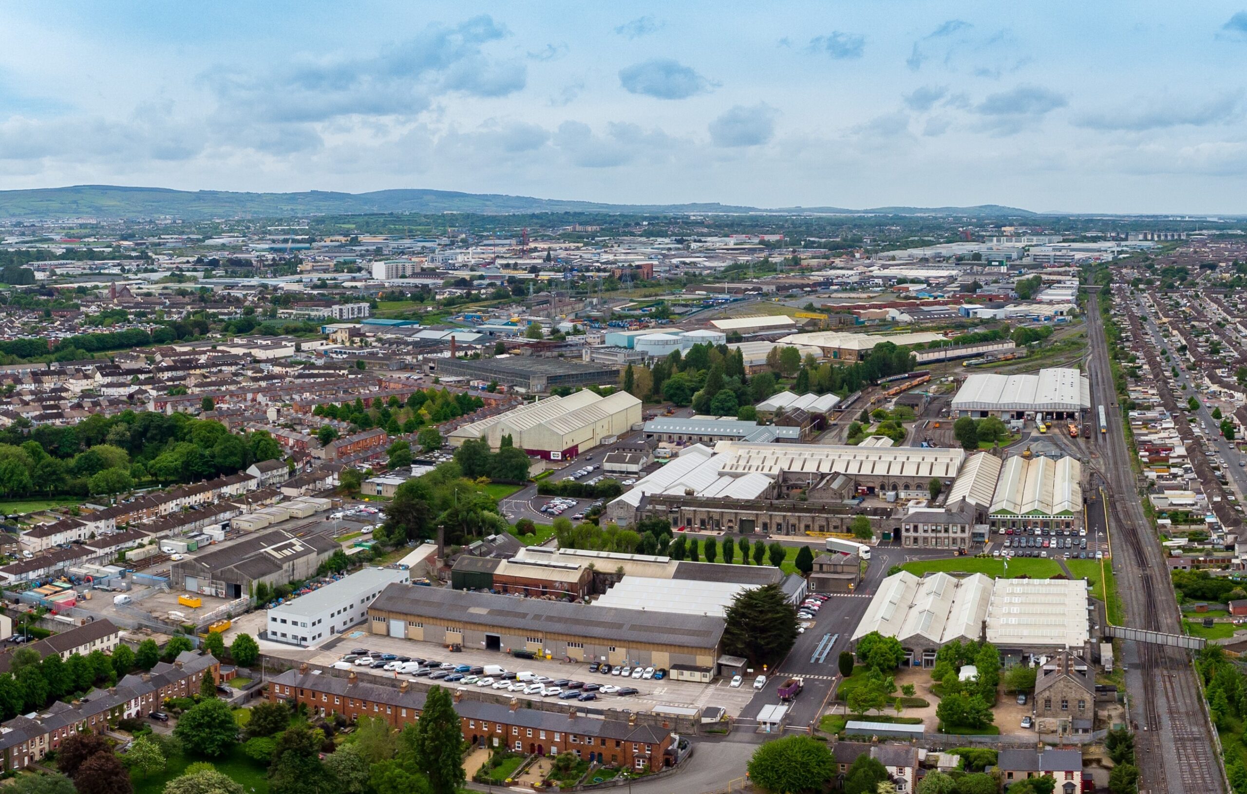 An aerial view of a cityscape with tall buildings and lush trees.