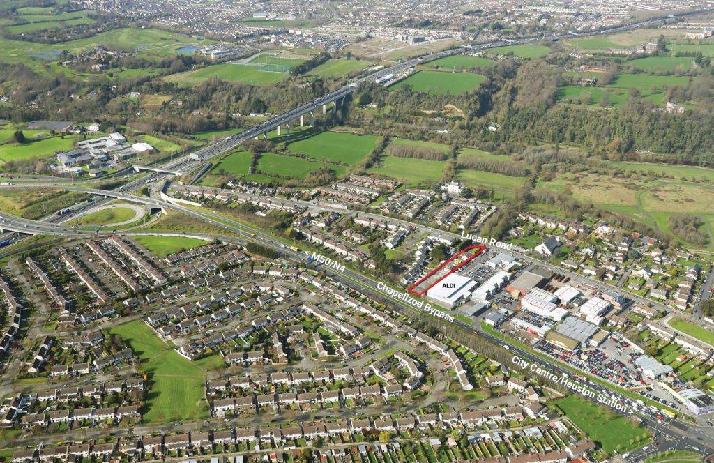 An aerial view of a city with a highway cutting through its bustling streets.