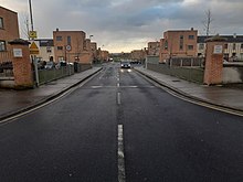 An empty street with an Expert Removals truck driving down it.