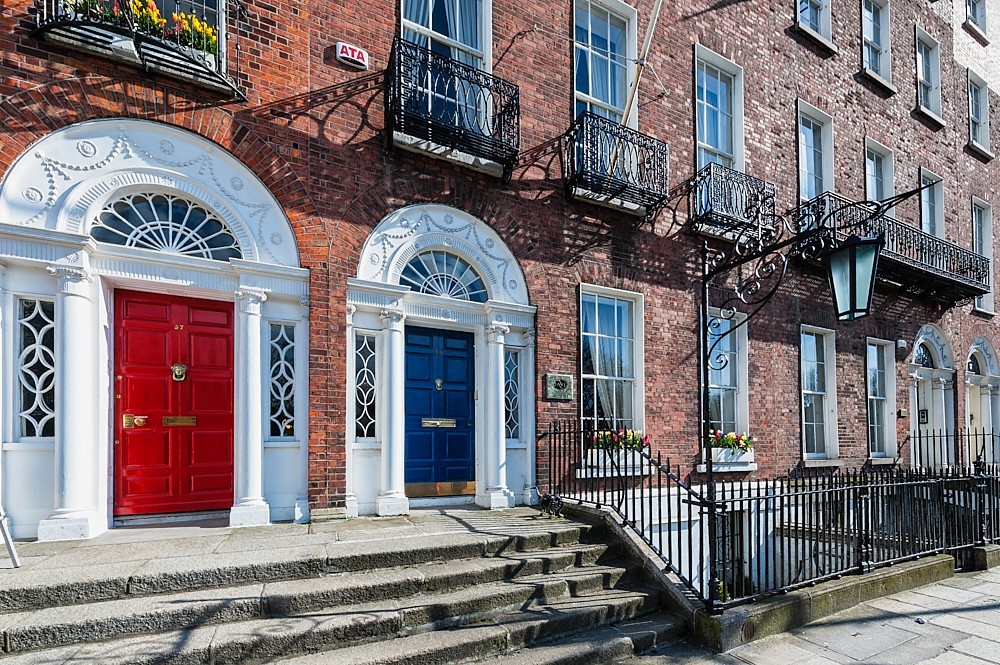 Red and blue doors on a brick building in Dublin, Ireland with Expert Removals signage.