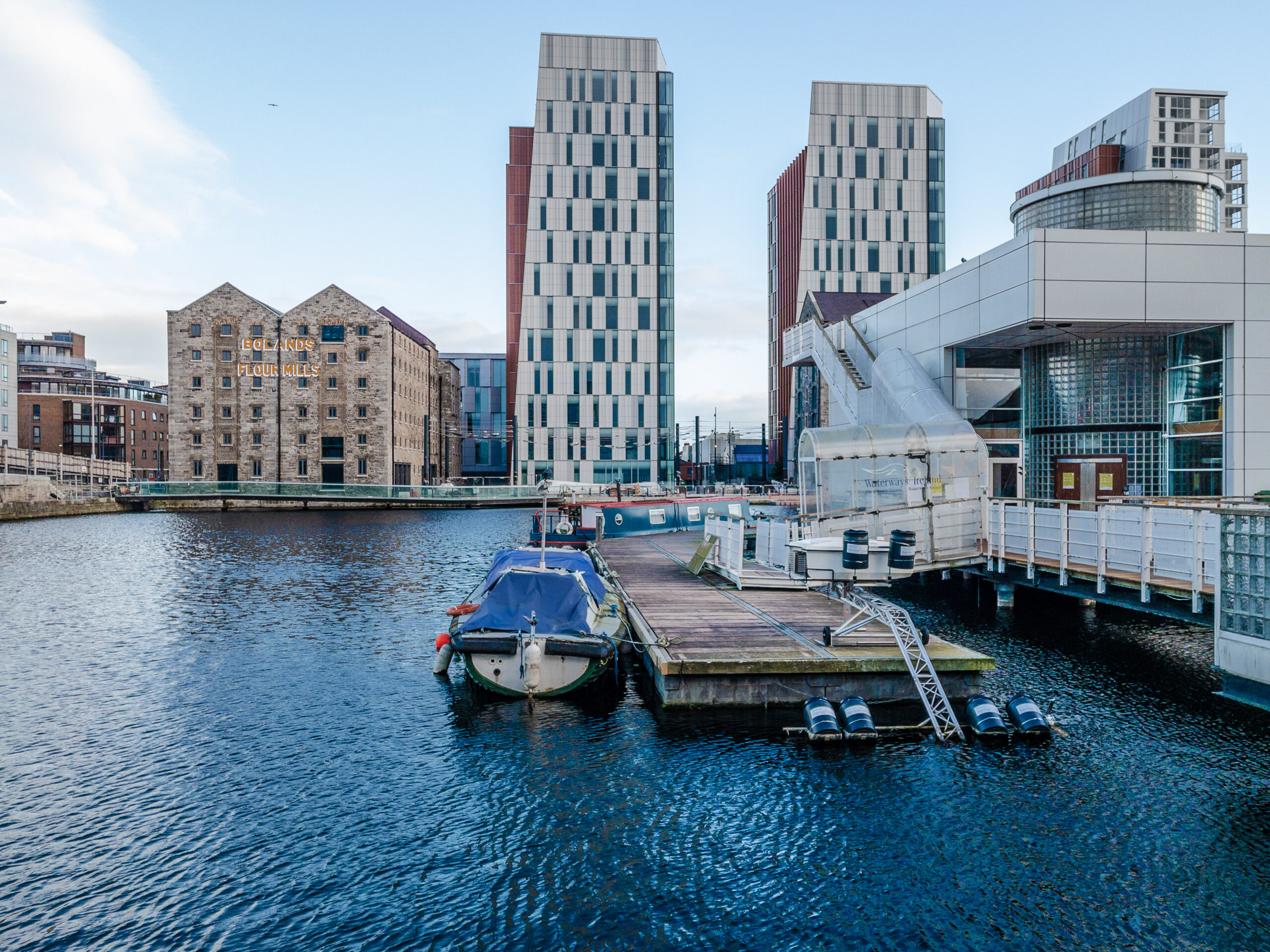 Expert Removals seamlessly transport a boat docked in a body of water.