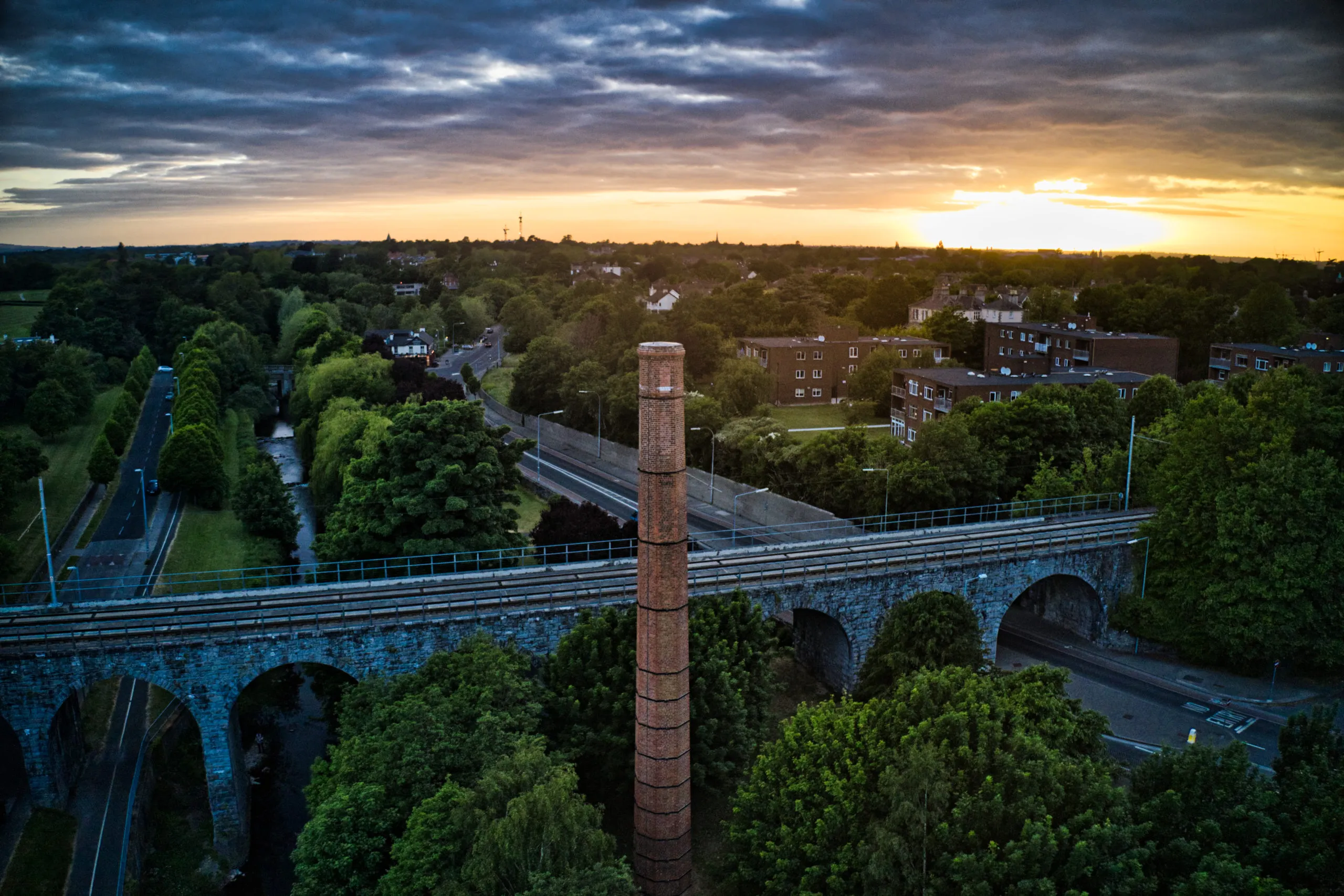 An aerial view of a train track and a chimney featuring Expert Removals.